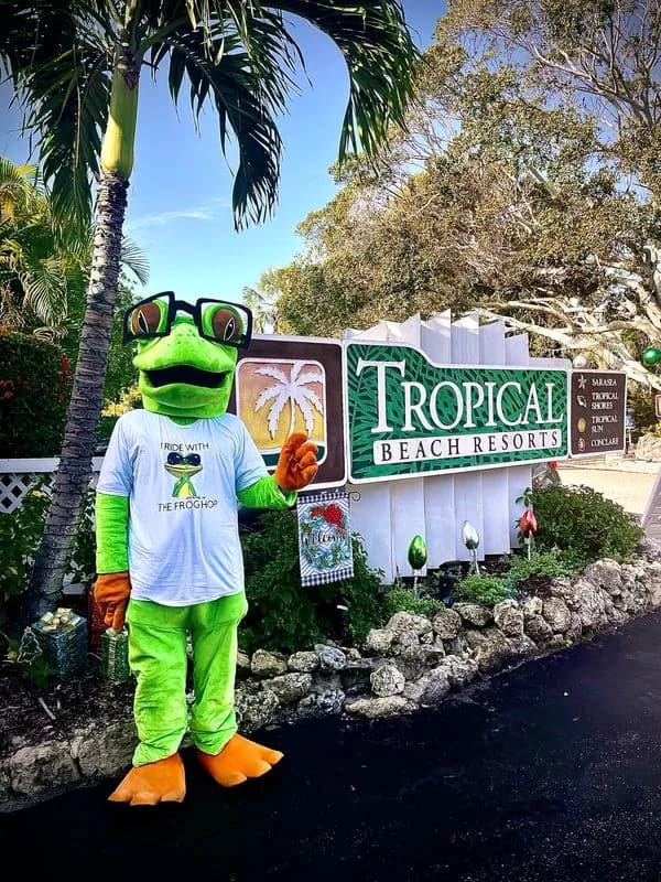The Frog Hop mascot in a tropical Siesta Key setting